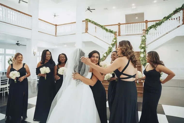 The bride and her bridesmaids, holding on