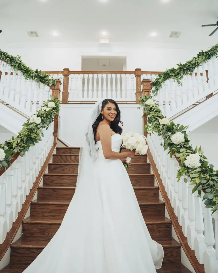 The bride on the staircase, bouquet in hand
