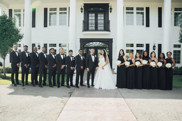 The full wedding party in front of the house