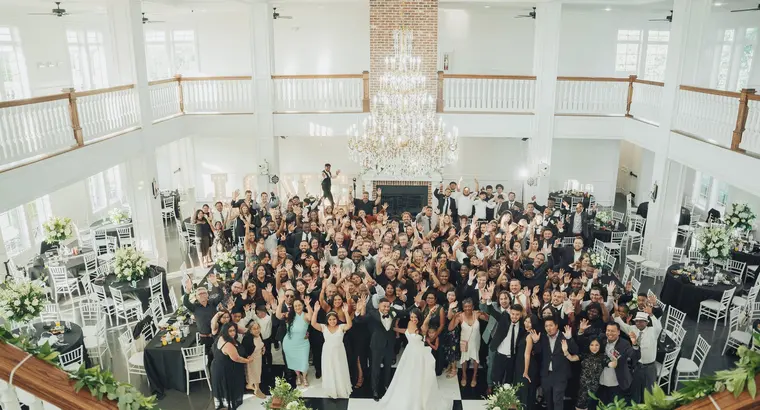 The whole room with their hands up, from the balcony above