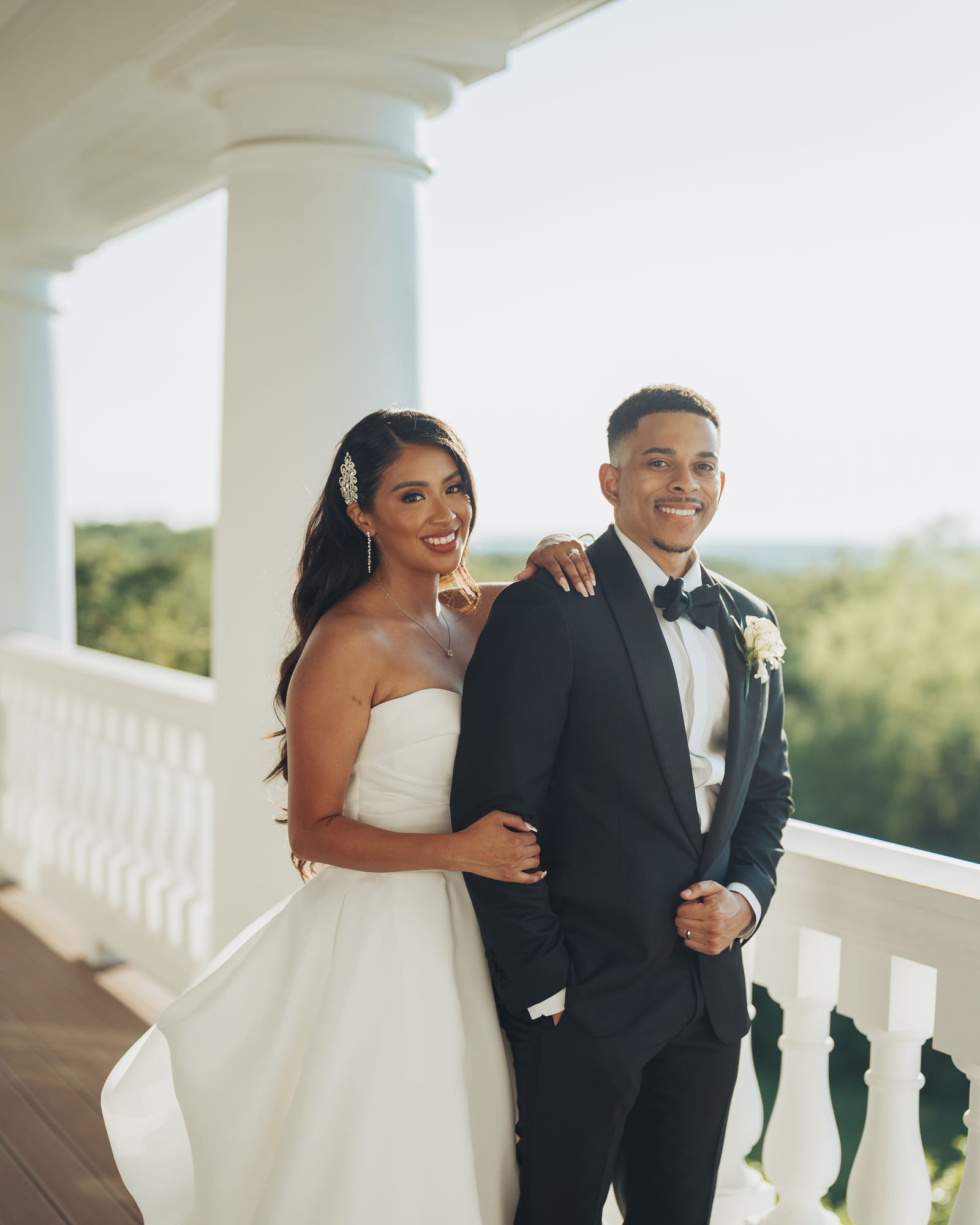 Demonte and his wife together on the balcony at their wedding, her hand resting on his shoulder