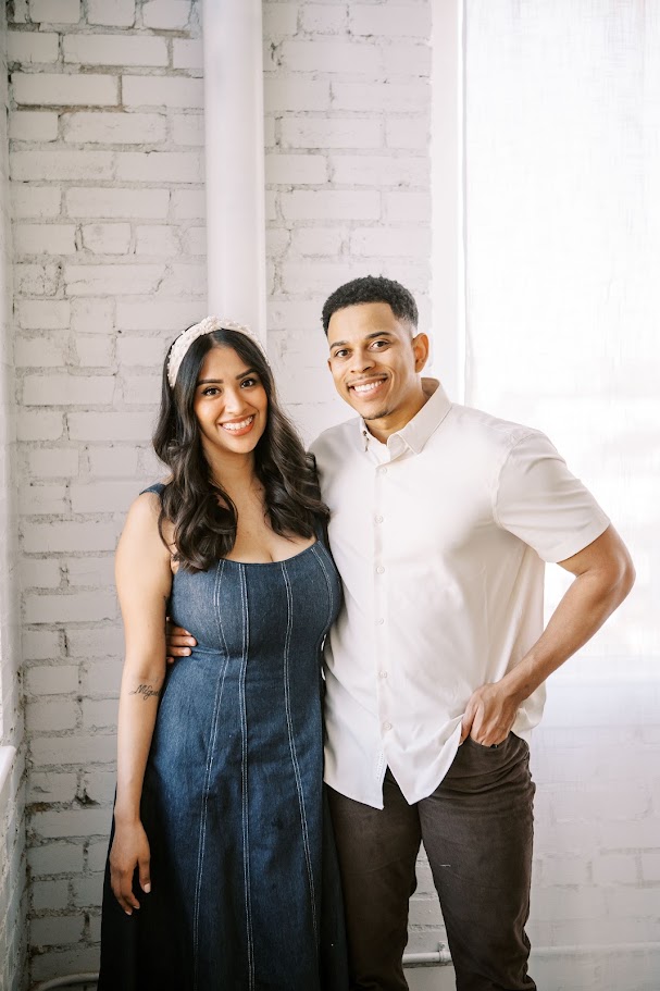 Demonte Johnson standing arm in arm with his wife against a brick wall